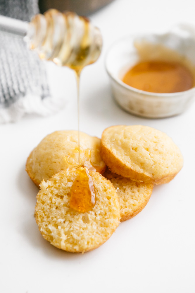 Drizzling honey onto cornbread muffins 