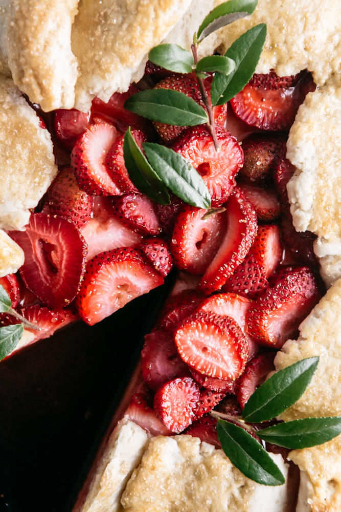Closeup of fresh strawberry galette with slice cut out. 