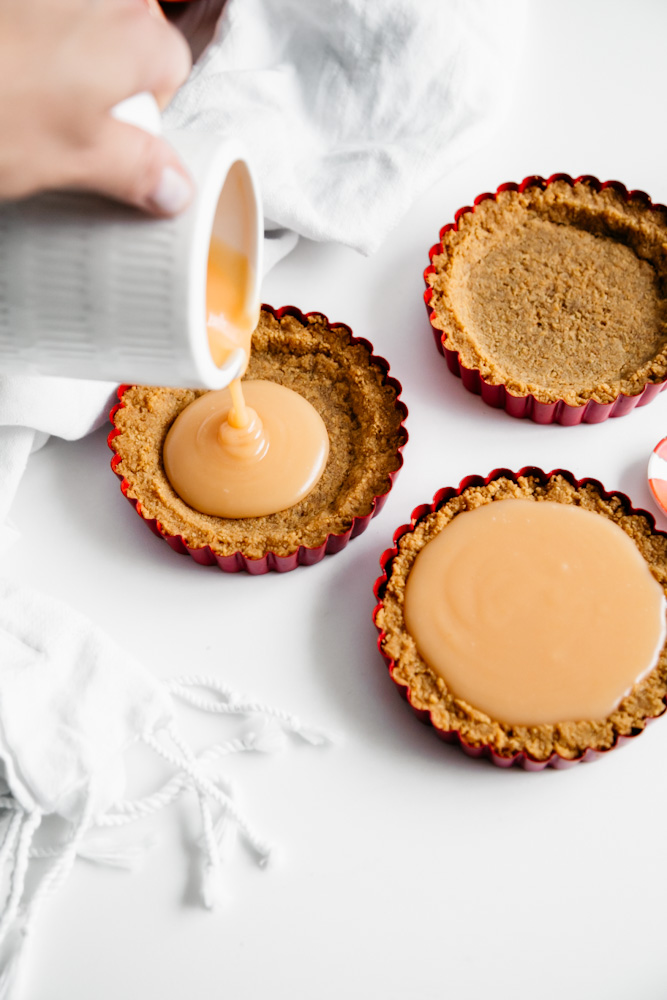 Pouring fresh grapefruit curd into tart shells. 