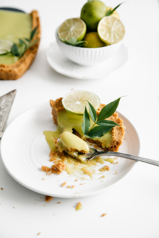 Slice of tart and a bowl of limes. 