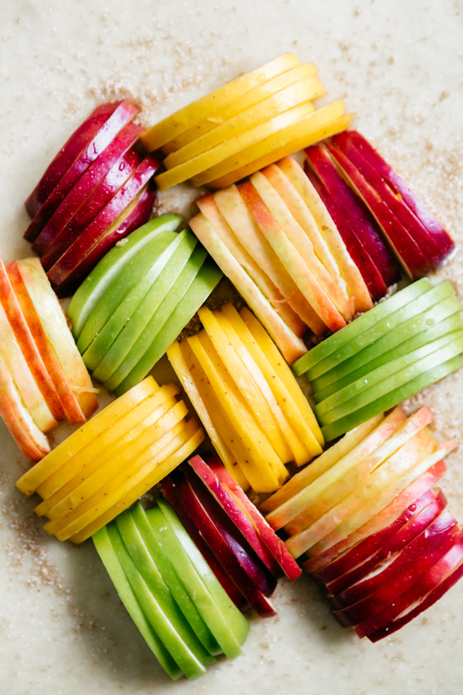 Colorful apples sliced onto rolled out dough 