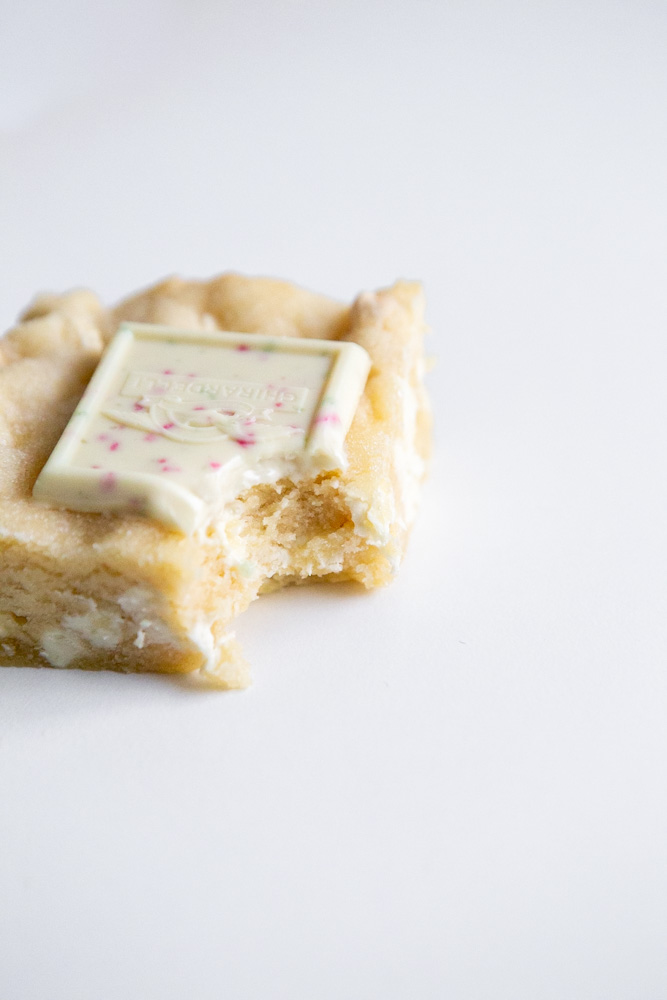 A bite of a white chocolate cookie bar 