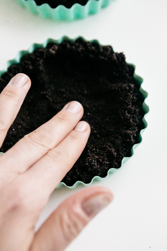 Pressing oreo crust into a tart pan 