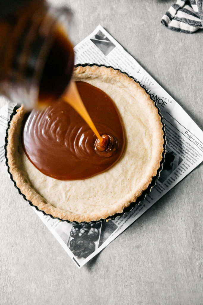 Pouring caramel into a tart 