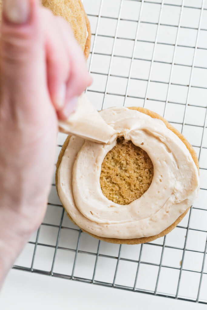 Piping frosting onto Churro Sugar Cookies 