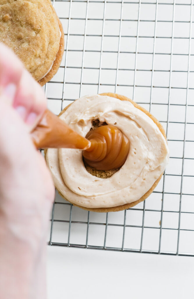 Filling Churro Sugar Cookies with caramel sauce 