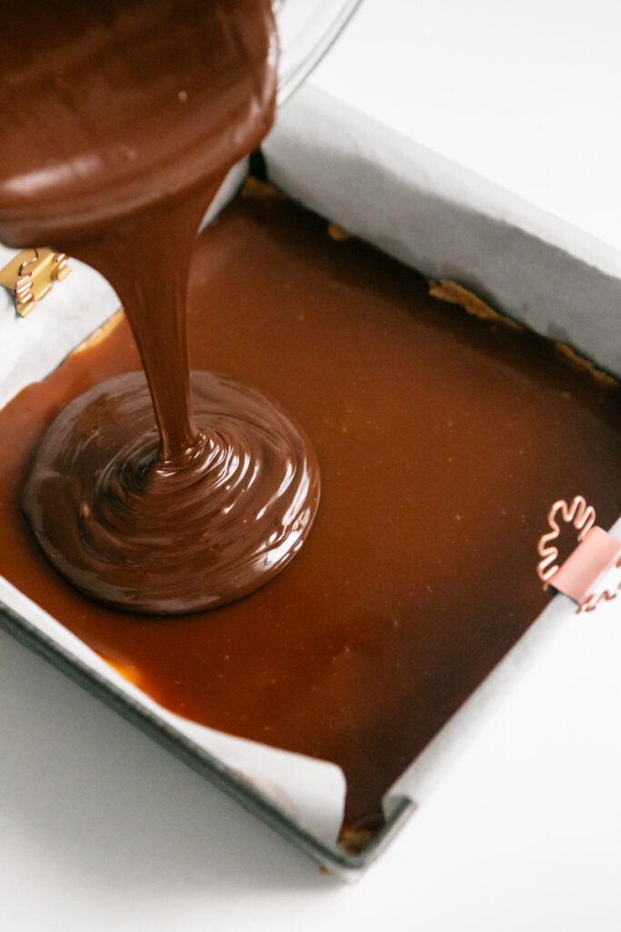 Chocolate drizzling onto caramel 