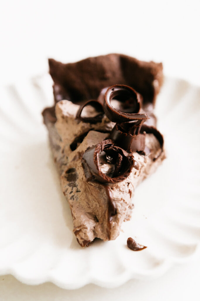 A slice of chocolate pie on a white dish 