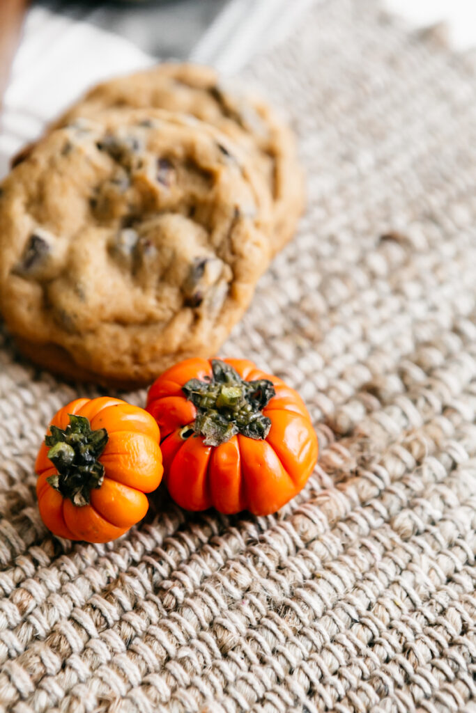 Two small orange pumpkins in front of cookies 