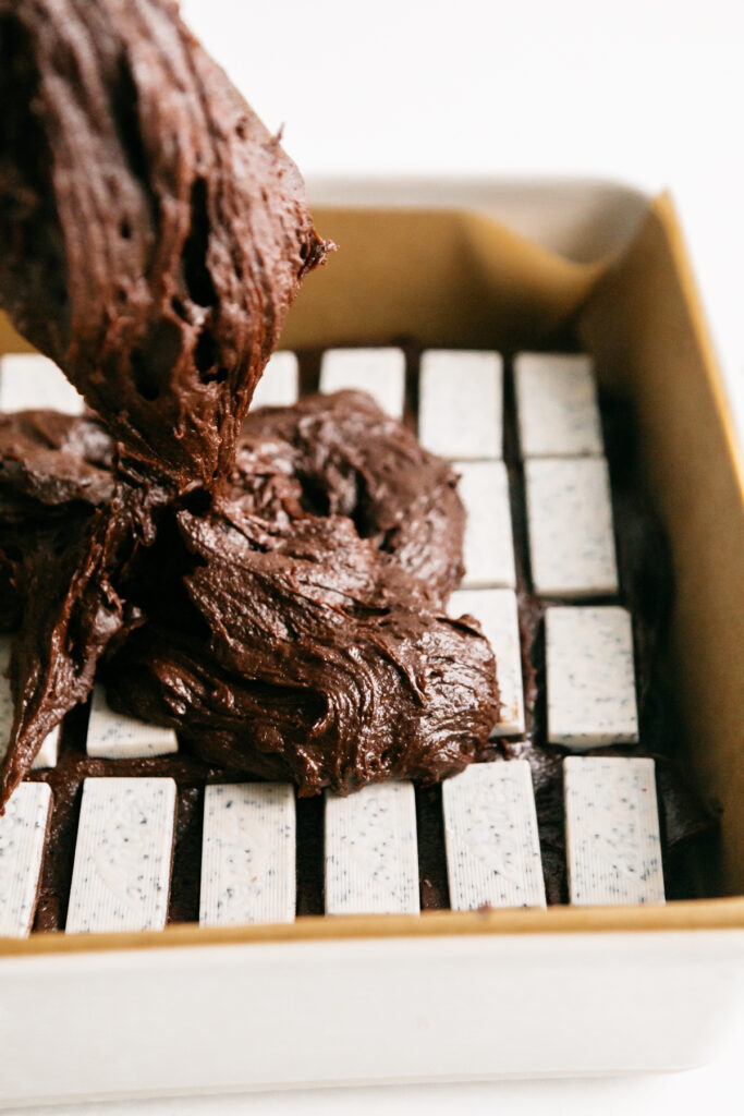 Pouring brownie batter into a pan 