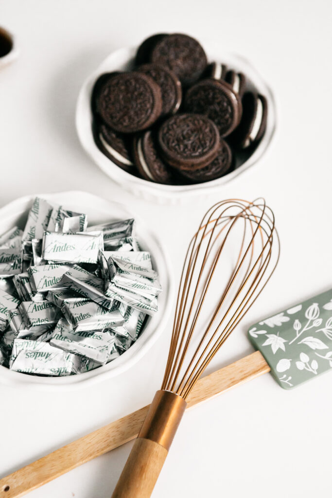 Oreos and mints in bowls with a whisk and spatula 