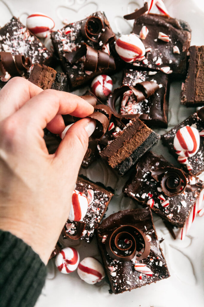 Placing a chocolate curl on a cheesecake bar 