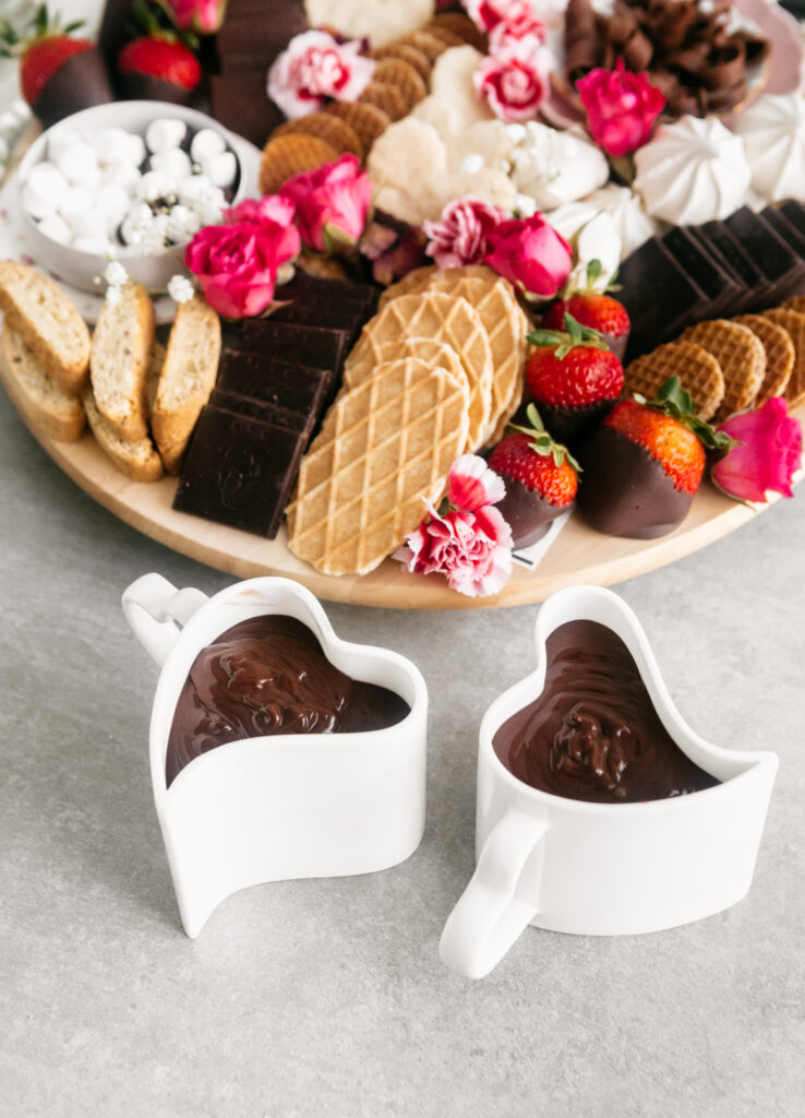 Dessert board with mugs of cocoa 