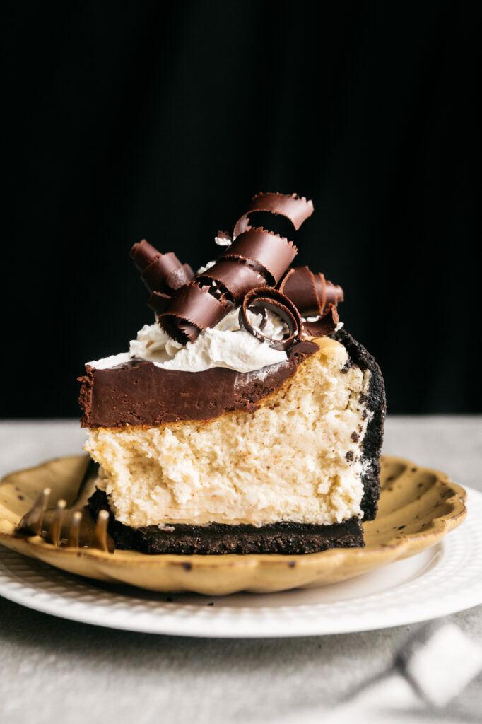 A slice of cheesecake with chocolate curls 