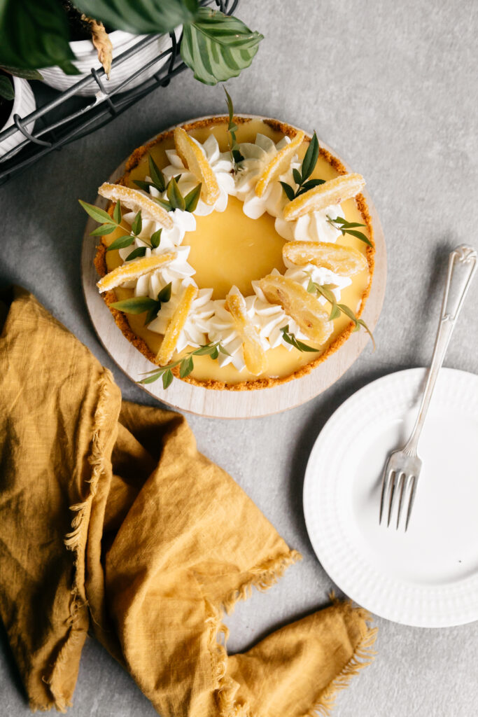 A cheesecake with a white plate and a yellow towel 