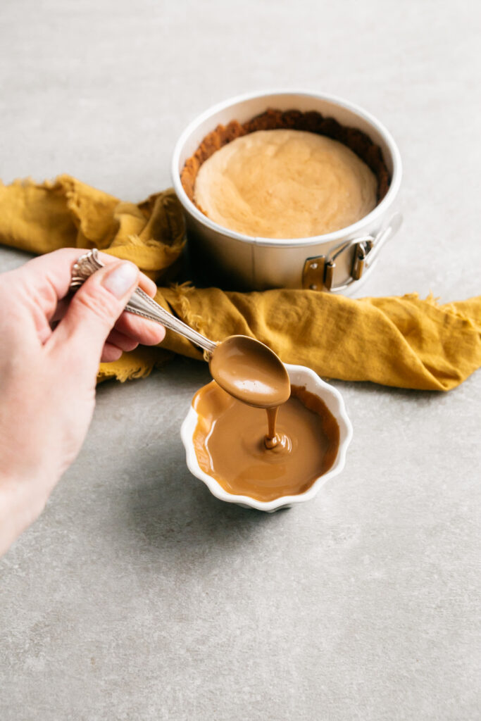 Cookie butter, melted, being spooned in a bowl. 