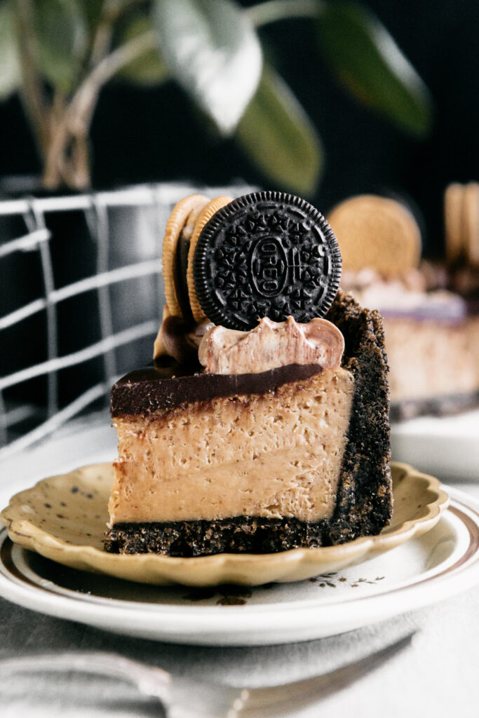 A slice of Peanut Butter Chocolate Cheesecake on a plate 