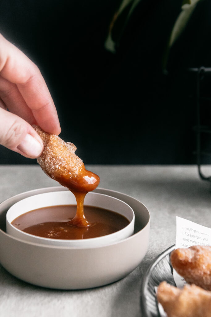 Dipping a cronut in caramel 