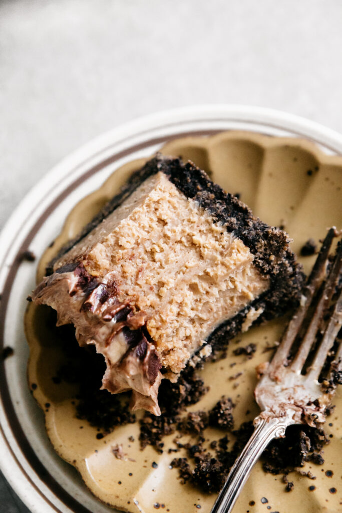 A slice of half eaten cheesecake on a plate 