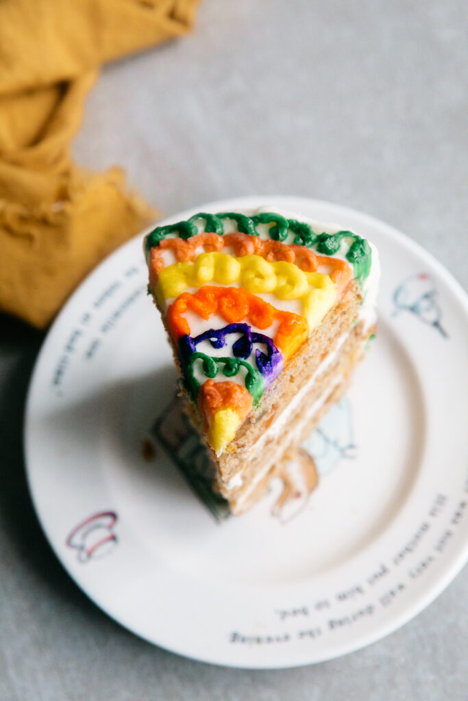 a slice of carrot cake with colorful buttercream 