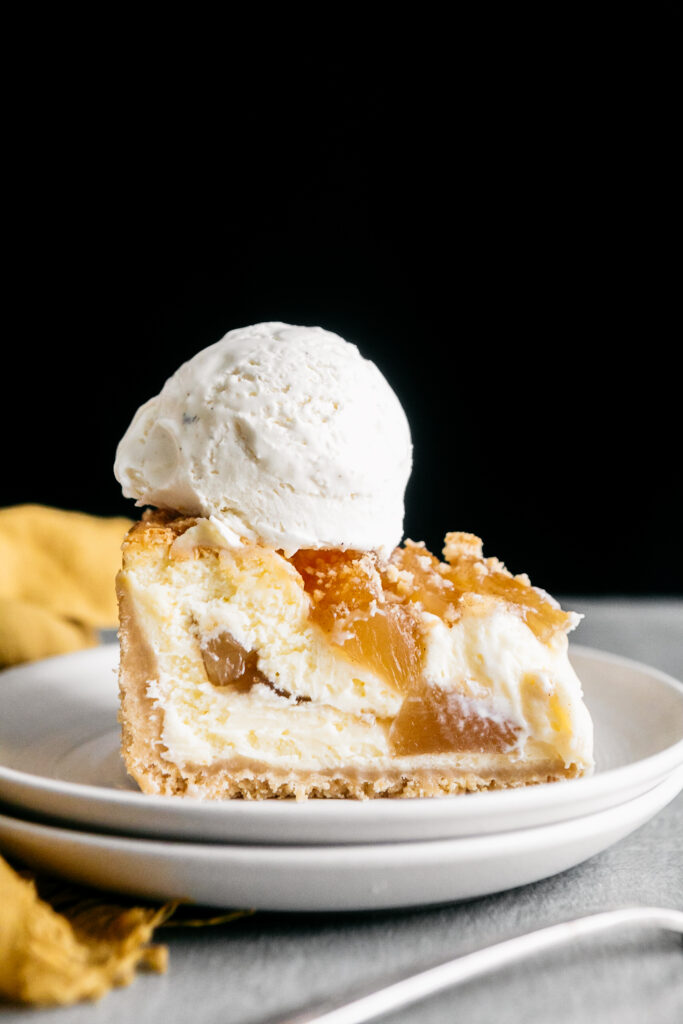 A slice of cheesecake with a scoop of ice cream 