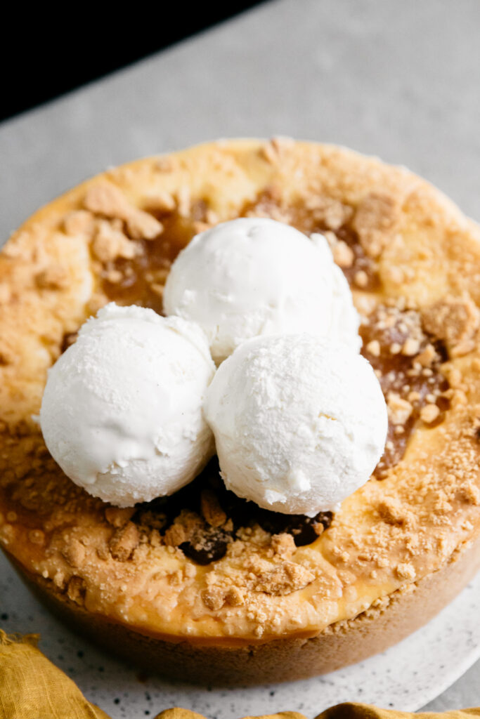 Ice cream scooped onto a cheesecake 