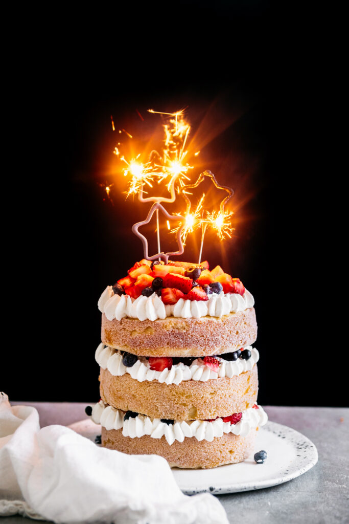 Classic Vanilla Layer Cake With berries and sparkler candles 