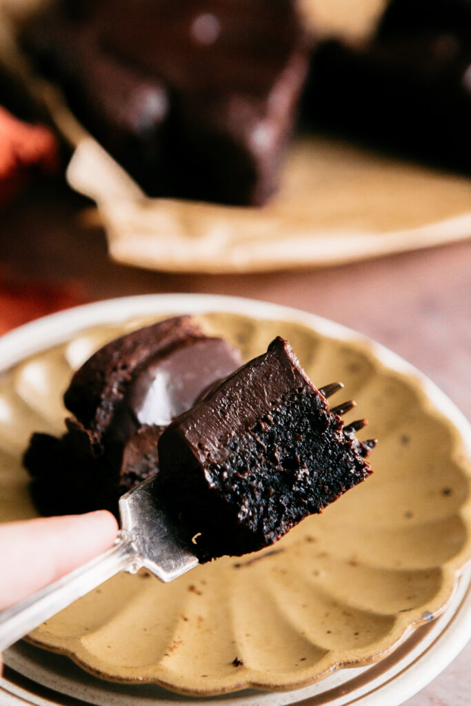 A fork with a bite of cake on it 