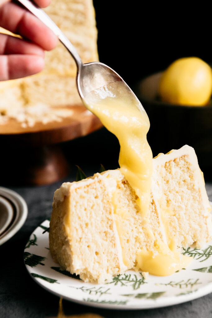 Drizzling lemon curd on a cake slice 