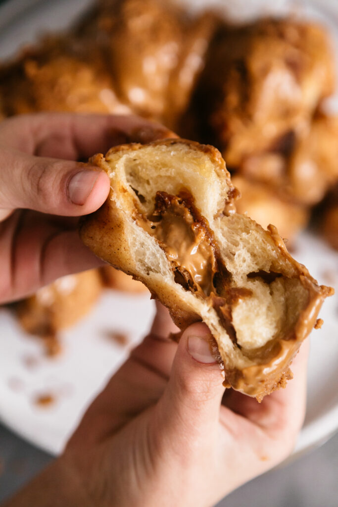 pulling apart stuffed monkey bread to show the inside 