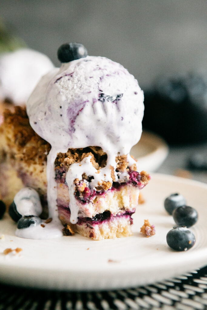 Browned Butter Blueberry Crisp Cheesecake with a scoop of blueberry ice cream 