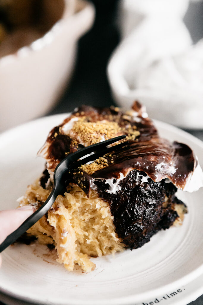 cutting a S'mores Cinnamon Roll with a fork 